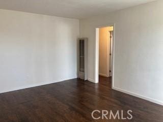 unfurnished room with dark hardwood / wood-style flooring