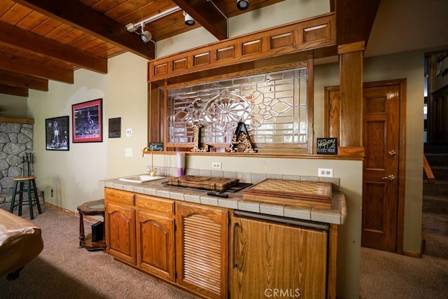 bar featuring beam ceiling, light colored carpet, tile counters, and wood ceiling