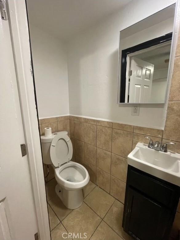 bathroom with tile patterned floors, vanity, and tile walls