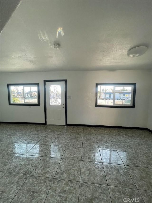 tiled entryway featuring a textured ceiling