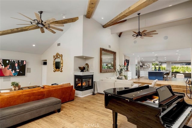 recreation room with beamed ceiling, light hardwood / wood-style floors, a multi sided fireplace, and high vaulted ceiling