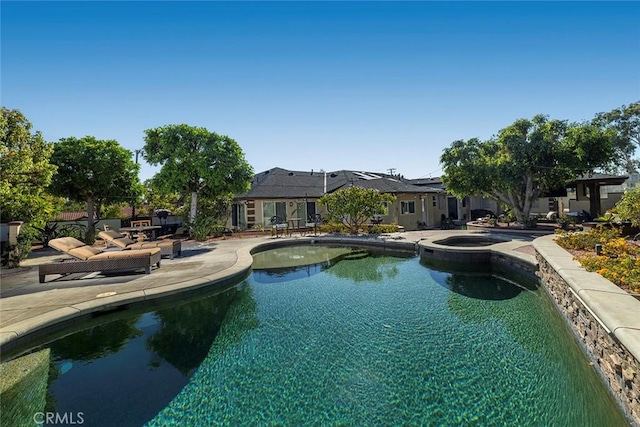 view of pool with an in ground hot tub and a patio