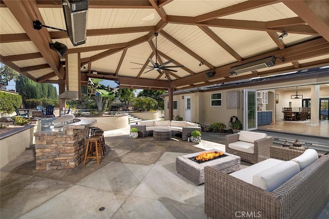 view of patio featuring a gazebo, an outdoor bar, ceiling fan, and an outdoor living space with a fire pit