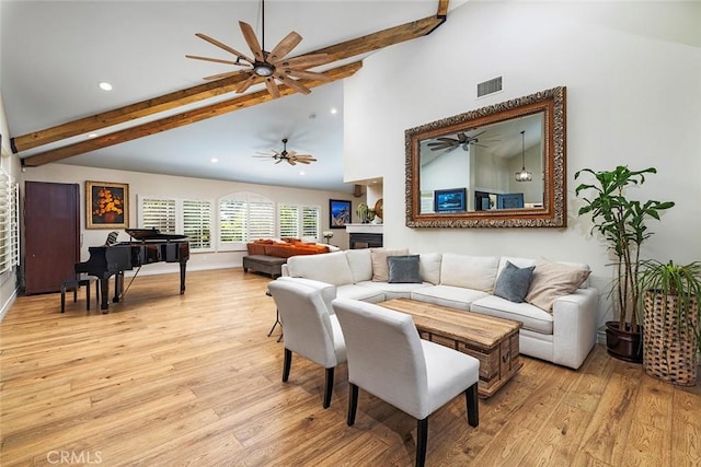 living room featuring vaulted ceiling with beams and light wood-type flooring