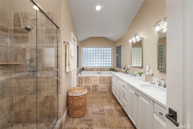 bathroom featuring vanity, vaulted ceiling, and independent shower and bath