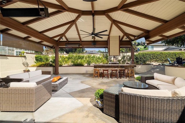 view of patio / terrace with a gazebo, exterior bar, and an outdoor living space with a fire pit