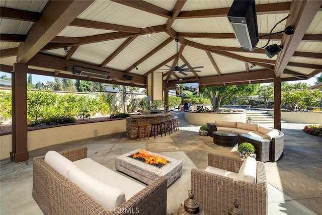 view of patio / terrace featuring a gazebo, ceiling fan, an outdoor living space with a fire pit, and an outdoor bar