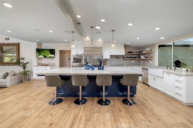 kitchen featuring light stone countertops, appliances with stainless steel finishes, light hardwood / wood-style floors, and white cabinets