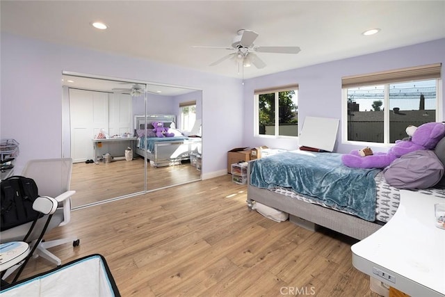 bedroom with ceiling fan, a closet, and light hardwood / wood-style flooring