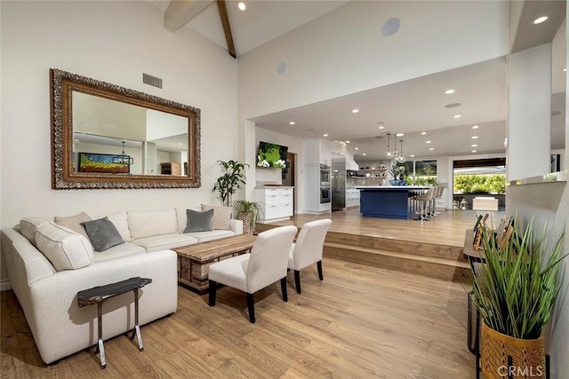 living room featuring beamed ceiling, light hardwood / wood-style floors, and high vaulted ceiling