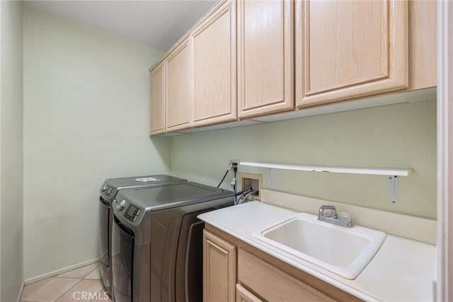 laundry area featuring cabinets, independent washer and dryer, light tile patterned floors, and sink