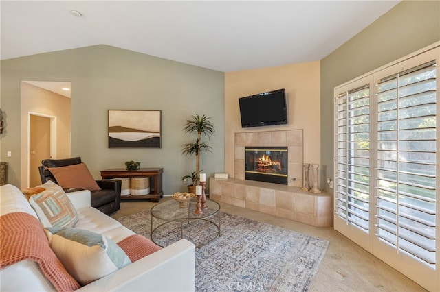 living room featuring a tile fireplace, light carpet, and vaulted ceiling