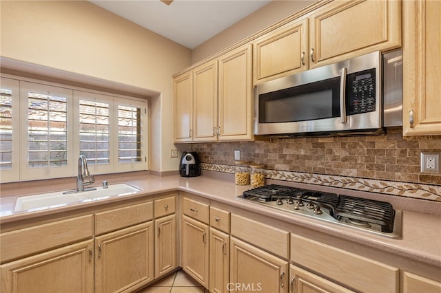 kitchen with decorative backsplash, sink, light tile patterned flooring, and stainless steel appliances