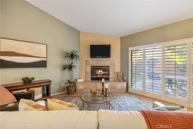 living room featuring lofted ceiling and a tiled fireplace