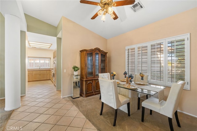 tiled dining space featuring ceiling fan, sink, and lofted ceiling