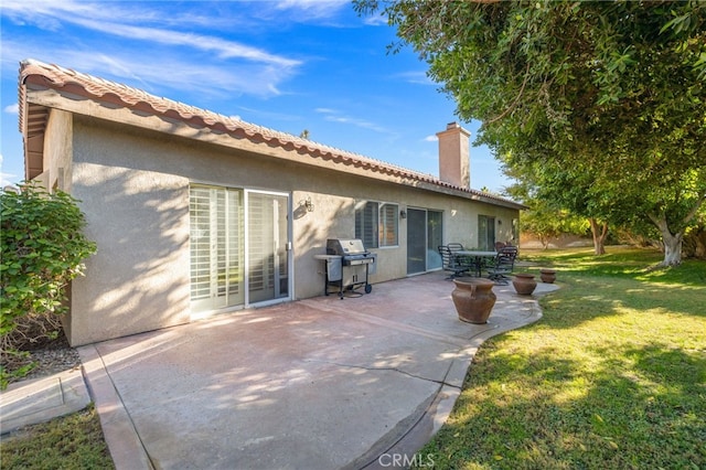 rear view of property with a patio area and a lawn