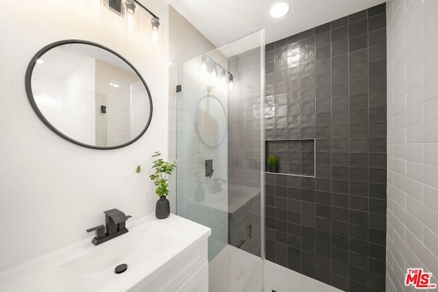 bathroom featuring vanity and a shower with door