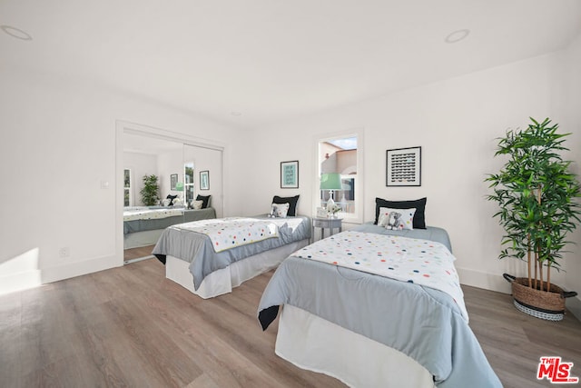 bedroom with connected bathroom and light hardwood / wood-style flooring