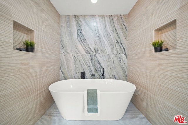 bathroom featuring a bathtub and tile walls