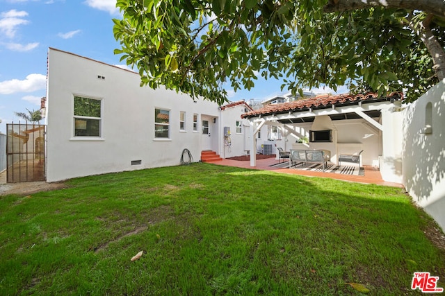 back of house featuring a lawn and a patio