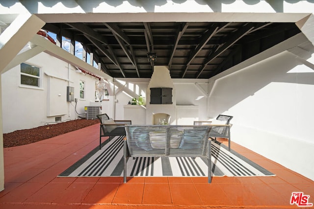 view of patio with central air condition unit and an outdoor fireplace