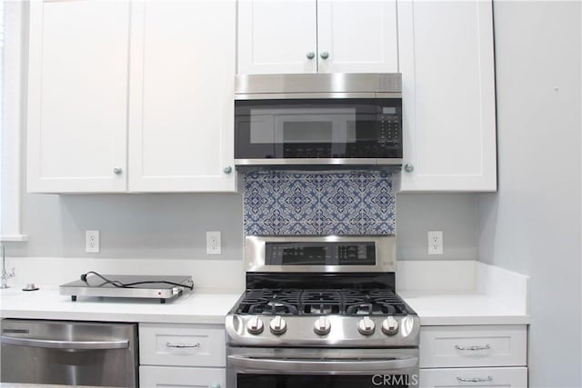 kitchen with decorative backsplash, white cabinetry, and appliances with stainless steel finishes