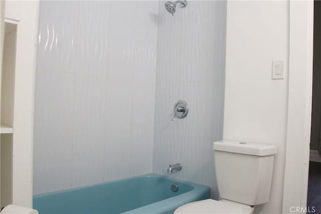 bathroom featuring toilet and tiled shower / bath