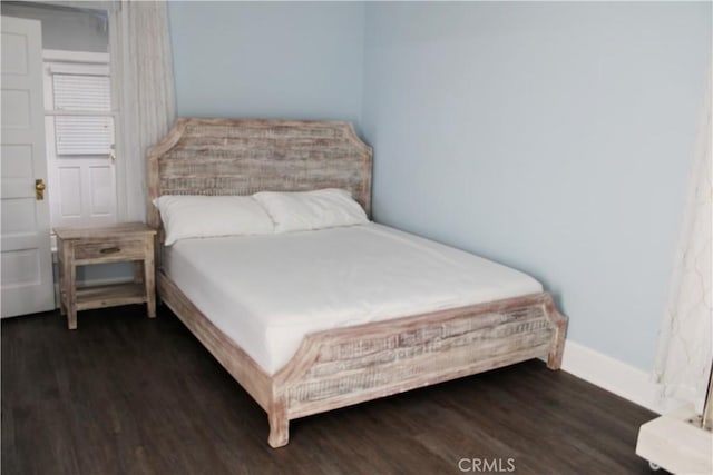 bedroom with dark wood-type flooring