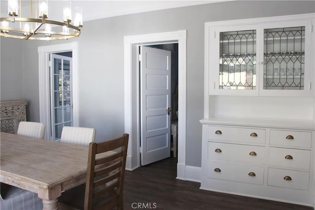 dining space featuring ornamental molding, dark hardwood / wood-style floors, and a notable chandelier