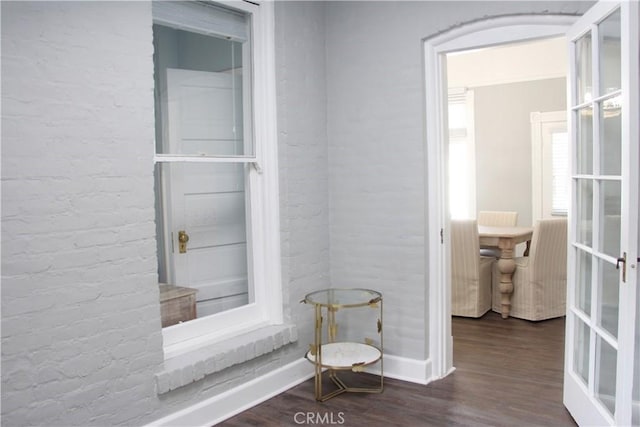 bathroom with hardwood / wood-style flooring, brick wall, and french doors