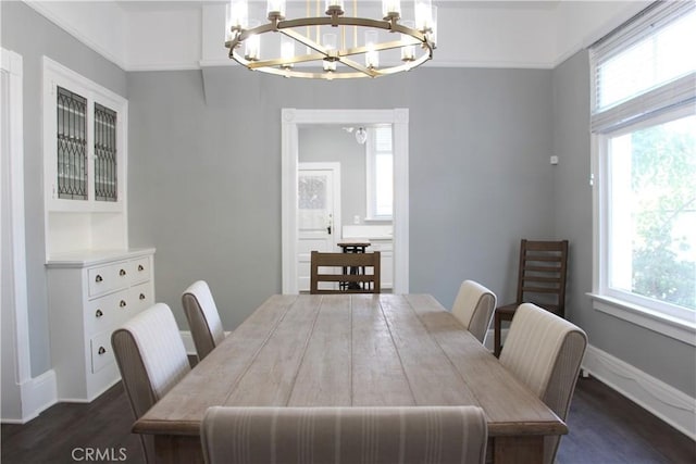 dining room featuring ornamental molding, plenty of natural light, dark wood-type flooring, and a notable chandelier