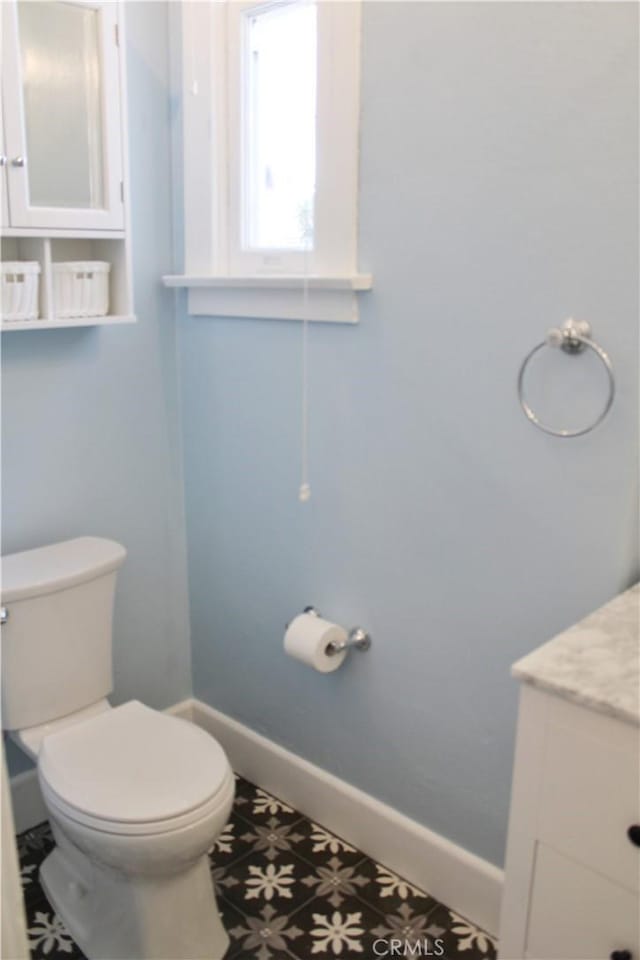 bathroom with tile patterned flooring, vanity, and toilet