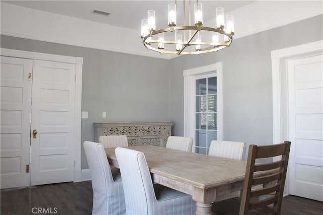 dining space with dark hardwood / wood-style floors and a chandelier