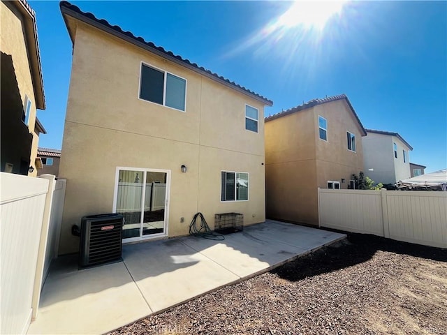 rear view of property featuring central AC and a patio area