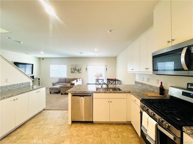 kitchen featuring appliances with stainless steel finishes, kitchen peninsula, and sink