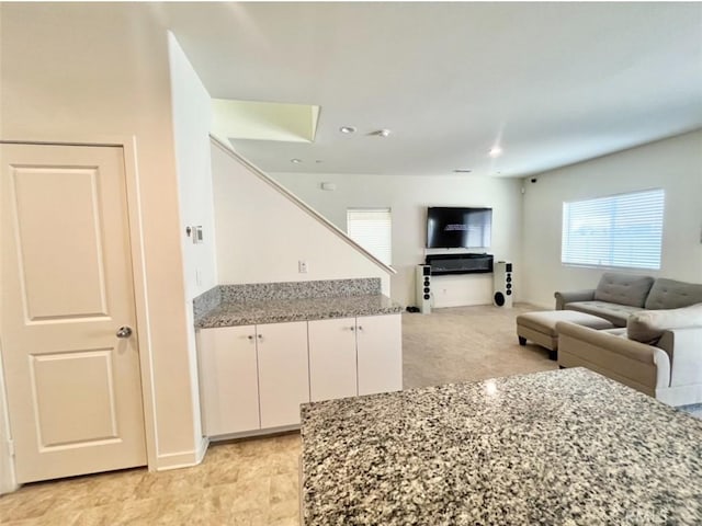 kitchen featuring white cabinetry and light stone counters