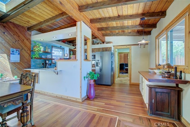 kitchen featuring white cabinetry, hanging light fixtures, wooden ceiling, vaulted ceiling with beams, and stainless steel refrigerator with ice dispenser