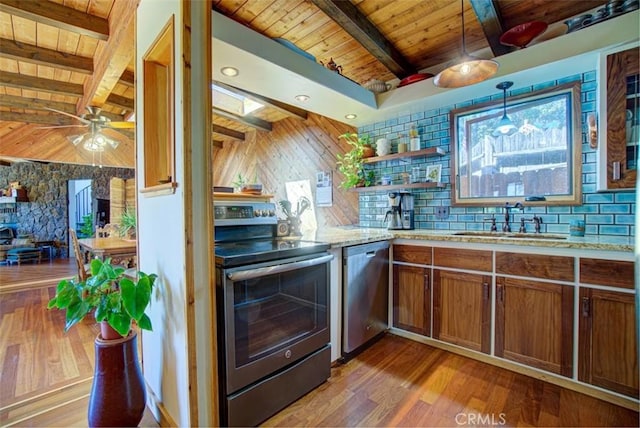 kitchen with beam ceiling, sink, hanging light fixtures, and appliances with stainless steel finishes