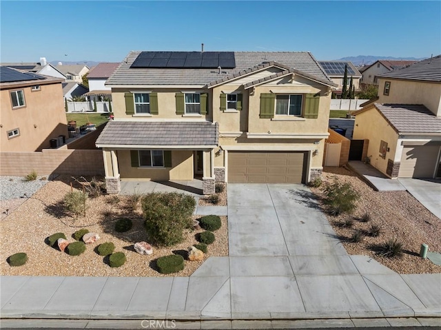 view of front of property featuring a garage and solar panels