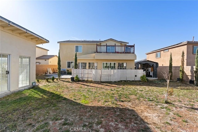 back of property featuring a gazebo and a yard