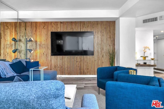 living room with wood walls and hardwood / wood-style flooring