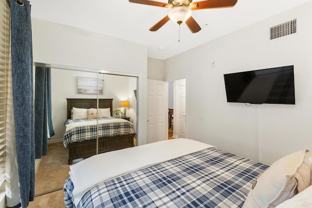 bedroom featuring a closet, visible vents, a ceiling fan, and light colored carpet