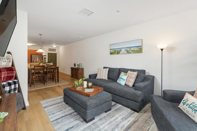 living area with light wood finished floors and visible vents