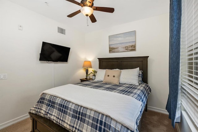 carpeted bedroom featuring ceiling fan, visible vents, and baseboards