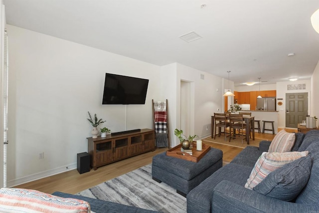 living area featuring light wood-type flooring and baseboards