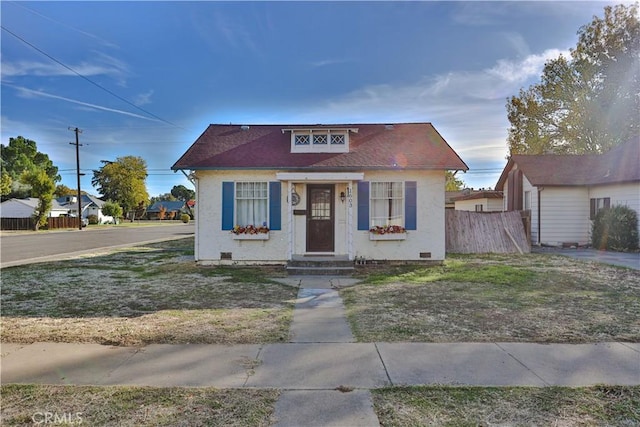 bungalow-style home featuring a front yard