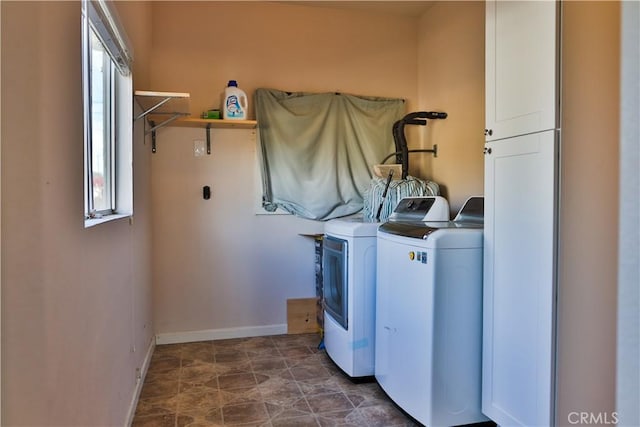 laundry area featuring washer and clothes dryer and cabinets