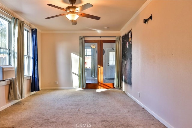 carpeted empty room featuring ceiling fan and crown molding