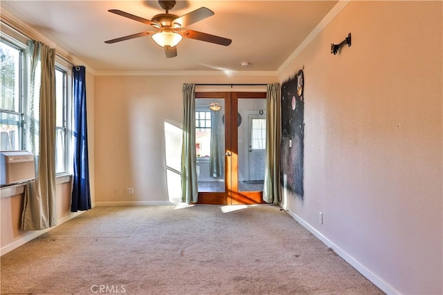 carpeted spare room with ceiling fan and crown molding