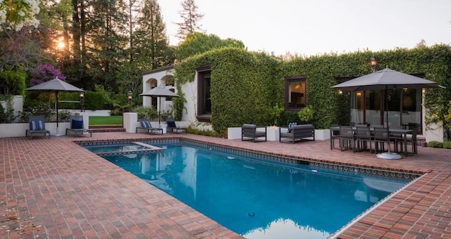 view of swimming pool featuring an in ground hot tub and a patio area